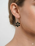 Black flower drop earrings with gold tone outline and hook fastening