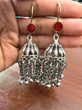 Silver tone jhumka earrings with chain tassels and red top accents